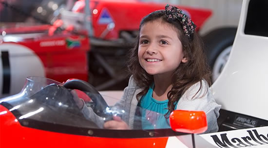 Girl sitting in F1 Racing Car at Brooklands Museum Weybridge Surrey