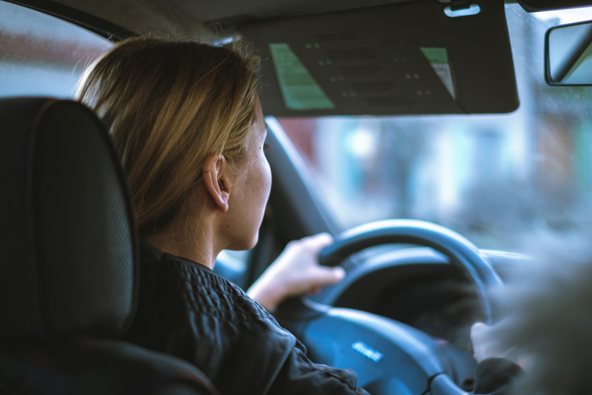 woman sitting in a car with a steering wheel photo